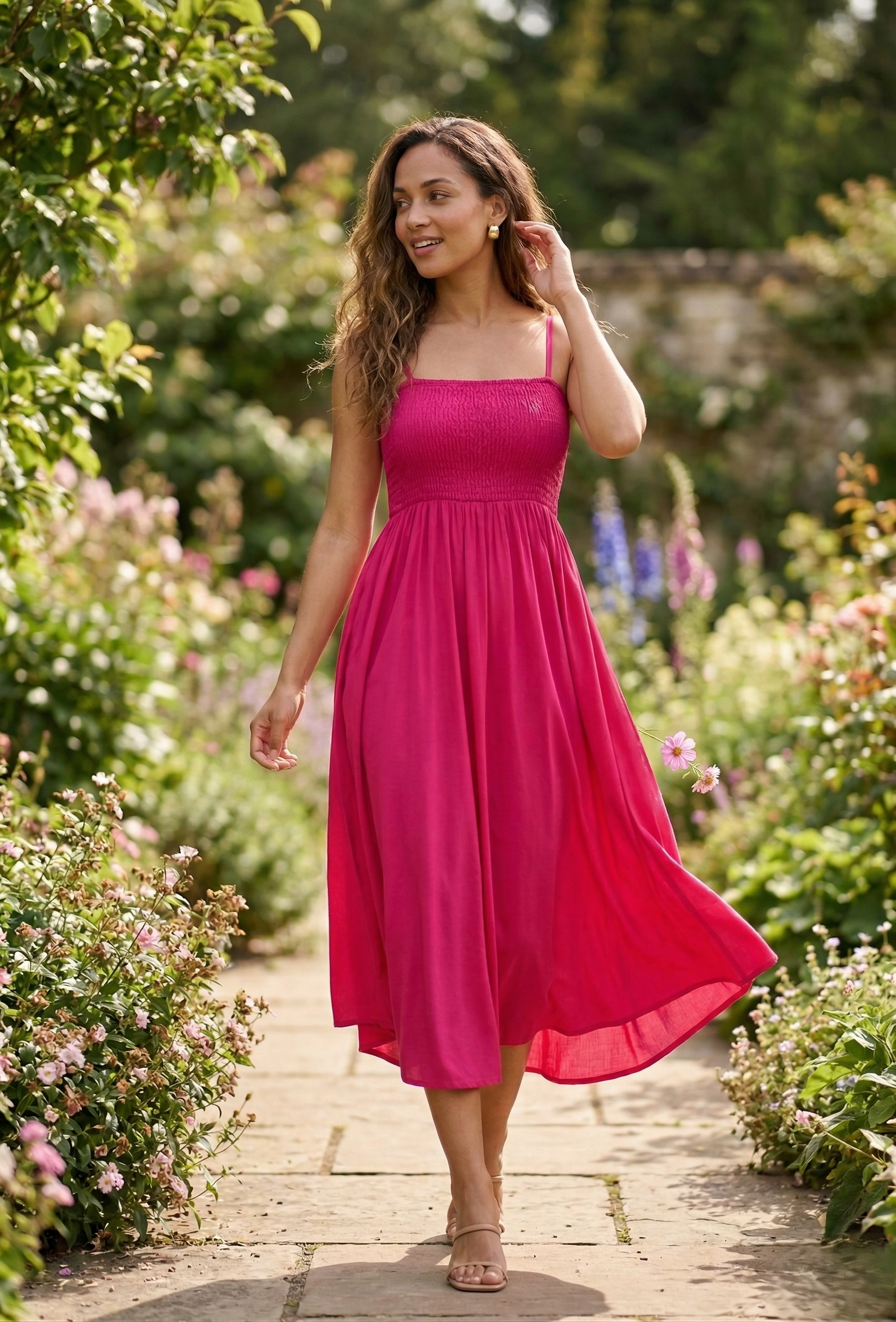 Stylish woman wearing a pink smocked midi dress standing confidently on a modern city street with skyscrapers in the background
