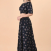 Side view of women black floral off shoulder co-ord set with long skirt
